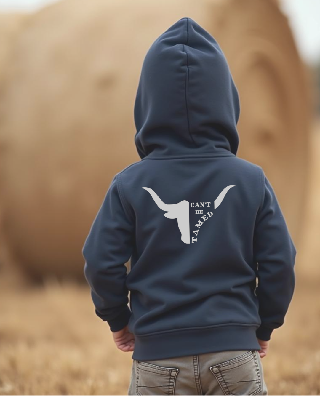 Back of a Young boy wearing a Navy coloured boys country western hoodie with small longhorn and text design by Sunburnt Country Clothing, Australian kids country clothing