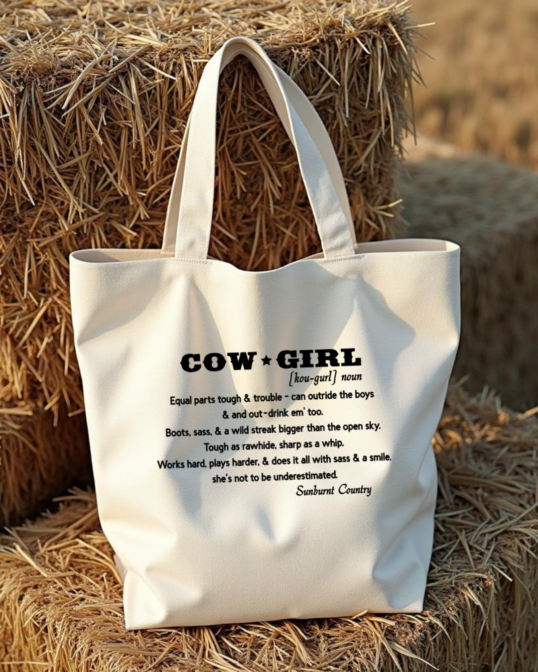 Sunburnt Country Clothing canvas tote bag with 'Cowgirl' definition text on hay bales