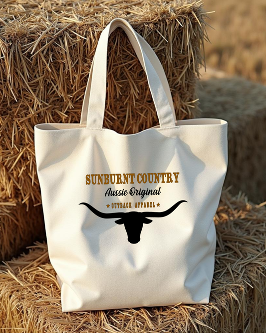 Sunburnt Country clothing canvas bag with 'Sunburnt Country' branding and longhorn on hay bales