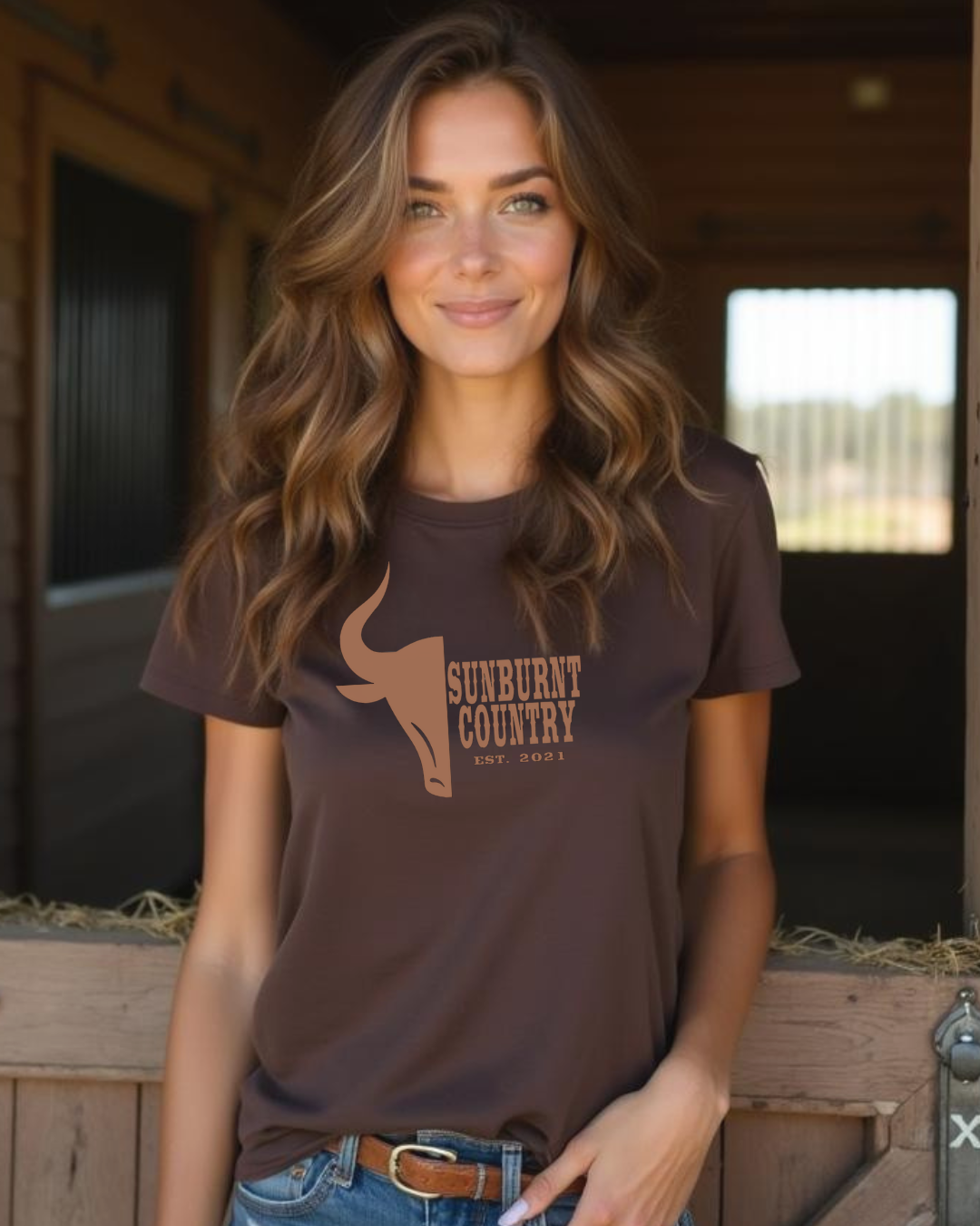 Female model wearing Sunburnt Country Clothing country t-shirt the stockman in front of horse stables 