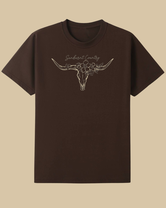 Sunburnt Country Clothing brown t-shirt with longhorn skull design on a beige background